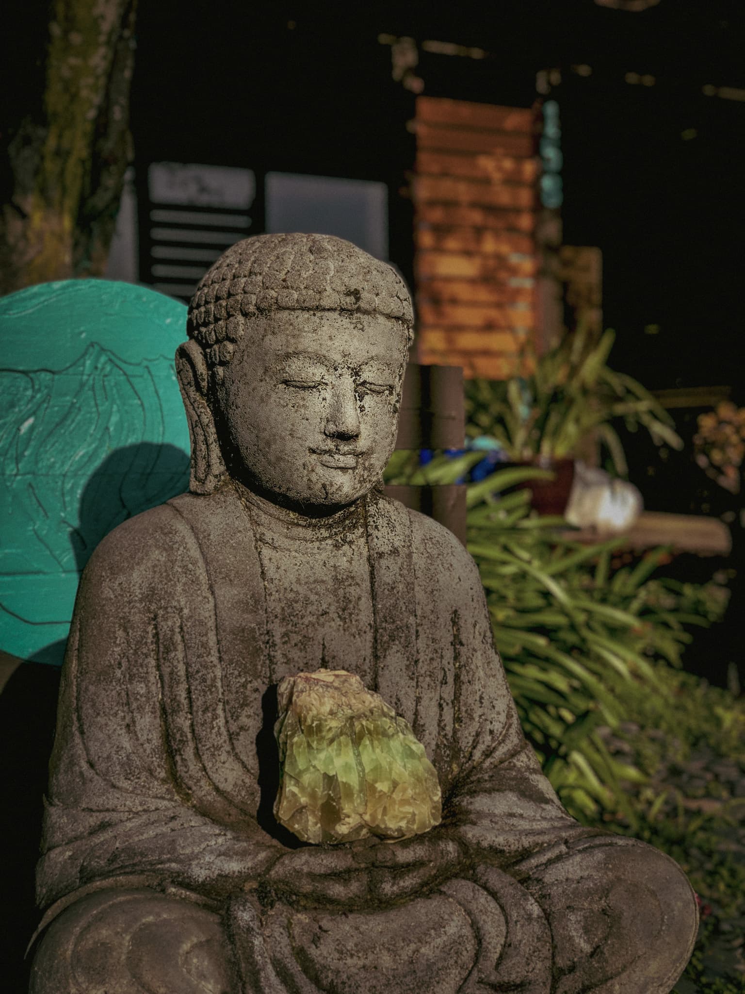 The weathered stone Buddha holding a crystal outside Almonte Spa